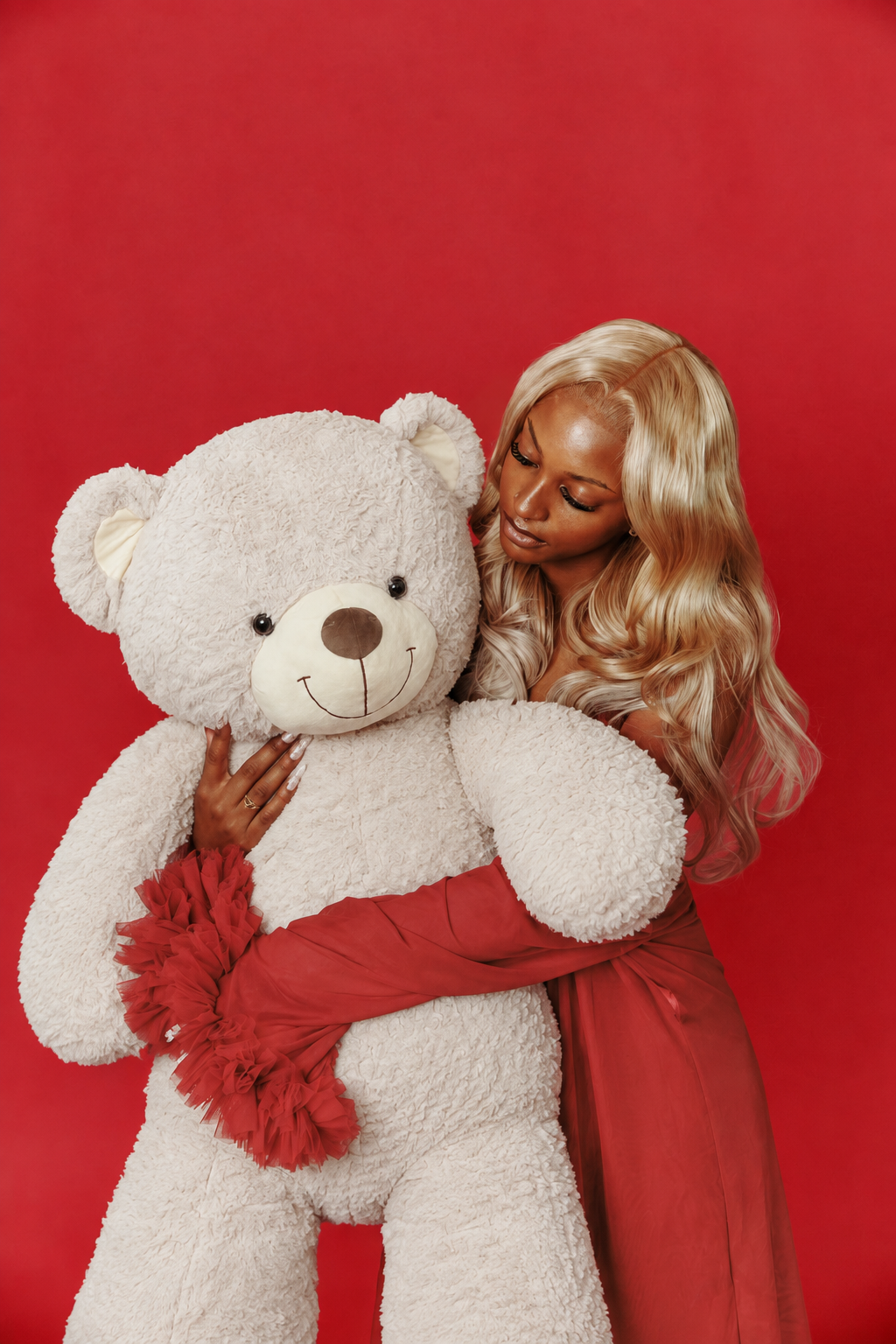 Femme tenant le nounours blanc sur fond rouge